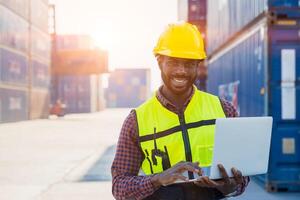 logistik industri afrikansk svart manlig ingenjör personal arbetstagare förman på hamn behållare gård kontrollera läser in frakt foto