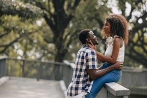 datum par man och kvinnor valentine dag. afrikansk svart älskare på parkera utomhus sommar säsong årgång Färg tona foto