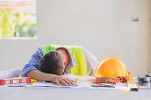 trött ingenjör konstruktion byggare man tupplur. arkitekt arbetstagare känsla utmattad sömn ner för hårt arbetande i arbetssätt skrivbord foto