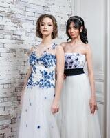 två kvinnor i vita klänningar foto