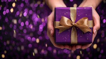 ai genererad elegant gåva låda med gyllene band i kvinna s händer på lila bakgrund med konfetti foto