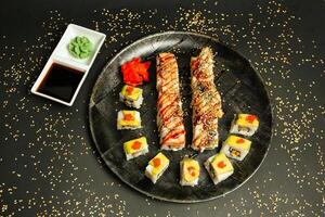 svart tallrik med sushi och sås foto