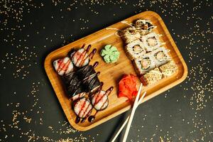 trä- bricka toppade med sushi och ätpinnar foto