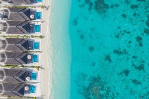 flygfoto av vackra maldiverna paradis tropisk strand. fantastisk utsikt, blå turkos lagunvatten, palmer och vit sandstrand. lyxresor semesterdestination. soligt flyglandskap foto