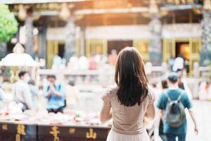 kvinna resande besöker i taiwan, turist med hatt sightseeing i longshan tempel, kinesisk folk religiös tempel i wanhua distrikt, taipei stad. landmärke och populär. resa och semester begrepp foto