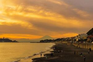 landskap kamakura yuigahama strand med kamakura stad och fujisan berg. skymning silhuett montera fuji Bakom enoshima ö på kamakura, kanagawa, japan. landmärke för turist attraktion nära tokyo foto