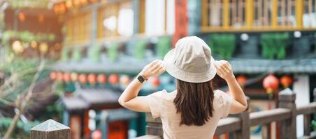 kvinna resande besöker i taiwan, turist med hatt sightseeing i jiufen gammal gata by med te hus bakgrund. landmärke och populär attraktioner nära taipei stad . resa och semester begrepp foto