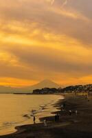 landskap kamakura yuigahama strand med kamakura stad och fujisan berg. skymning silhuett montera fuji Bakom enoshima ö på kamakura, kanagawa, japan. landmärke för turist attraktion nära tokyo foto