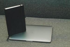 bärbar dator serier platt metall på de tabell med en företag dagbok. foto