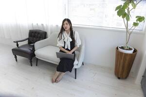en japansk kvinna kontroll smartphone förbi avlägsen arbete i de Hem kontor foto