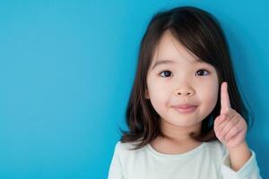 ai genererad asiatisk barn Framställ på blå bakgrund, pekande upp foto