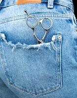 professionell frisering sax lögn i de tillbaka ficka av jeans .hög kvalitet Foto