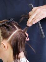 frisersalong händer delning de hår på de klient huvud. selektiv fokus.hög kvalitet Foto