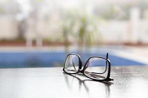 glasögon lögn på en mörk trä- tabell. svart glasögon med dioptrar på en trä- tabell. hög kvalitet Foto