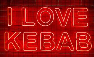 neon lysande tecken i röd Färg på en tegel vägg med de inskrift eller slogan jag kärlek kebab. tegel vägg, bakgrund. ljus elektrisk neon ljus. café-restaurang doner kebab. foto