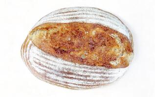 hemlagad utsökt bröd med vete mjöl på en skorpa på en vit bakgrund, platt lägga. friska handgjort surdeg bröd, Hem bakning begrepp. foto