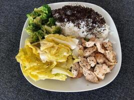 hemlagad grillad kyckling med ris och broccoli, eras på en vit tallrik foto