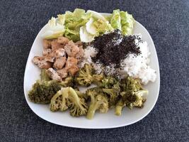 hemlagad grillad kyckling med ris och broccoli, eras på en vit tallrik foto