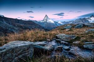 soluppgång över matter berg på äng och ström strömmande på zermatt, schweiz foto