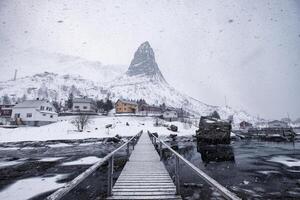 berg och scandinavian by på kustlinje i tung häftig snöstorm foto