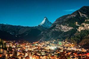 zermatt lantlig stad lysande i de alps med matter ikoniska topp i de natt på valais, schweiz foto