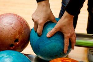 kvinnas hand väljer en bowling boll foto