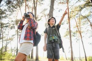 liten pojke och flicka gå vandring på en skog väg foto