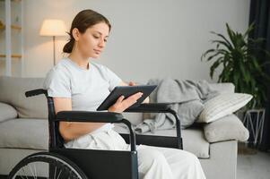 ung kvinna i rullstol på Hem i levande rum. foto