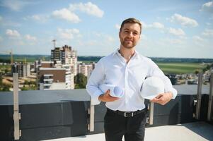 företag arkitekt man bär Hardhat stående av en byggnad projekt foto