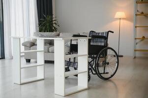 tömma rullstol i levande rum Nästa till de soffa foto