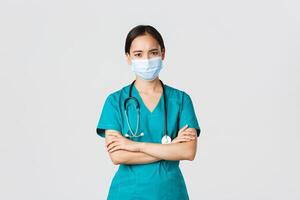 covid19, coronavirus sjukdom, sjukvård arbetare begrepp. bekymrad och orolig seriöst utseende asiatisk kvinna läkare underrätta patient dålig resultat, ha på sig medicinsk mask och skrubbar, se besviken foto