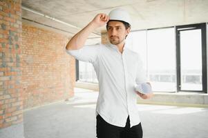 företag arkitekt man bär Hardhat stående av en byggnad projekt foto