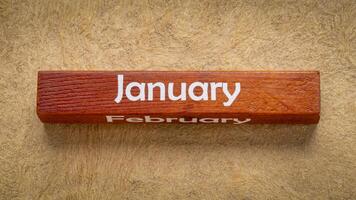 januari och februari text på trä- blockera mot handgjort bark papper i jord toner, kalender begrepp foto