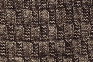 bakgrund med grå stickat blad form, stickning mönster med kablar. topp se, närbild. handgjort stickning ull foto