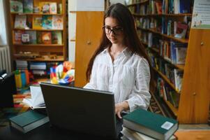 porträtt av en studentflicka som studerar på biblioteket foto