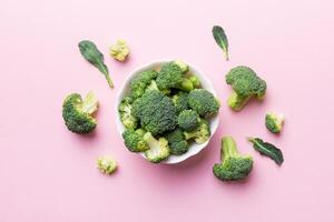 grön färsk broccoli bakgrund stänga upp på färgad tabell. grönsaker för diet och friska äter. organisk mat foto