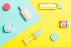 topp se av kosmetisk behållare, sprayer, burkar och flaskor på gul och blå bakgrund. närbild se med tömma Plats för din design foto