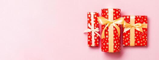gåva låda med guld rosett för jul eller ny år dag på rosa bakgrund, topp se foto