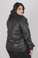 en kvinna i en svart läder jacka och svart byxor foto