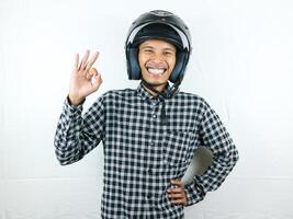 porträtt asiatisk man innehav motorcykel hjälm med upphetsad uttryck. säkerhet ridning. foto