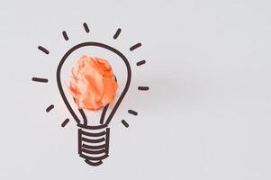 ny idéer och kreativ tänkande innovation begrepp. papper skrot boll orange Färg med ljus Glödlampa symbol på vit bakgrund foto