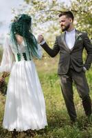 en skäggig brudgum och en flicka med grön hår dansa och snurra foto
