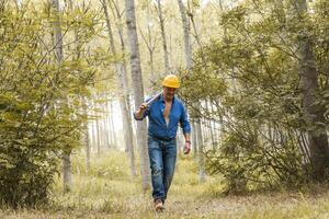 professionell skogsarbetare är gående i de skog med en yxa foto