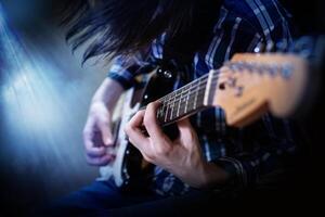 en ung män spelar elektrisk gitarr foto