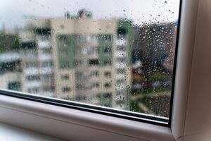 regndroppar på fönsterglas. selektiv fokusering. regnig stad bakgrund foto