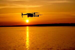 Drönare quadcopter med digital kamera flygande på solnedgång. skön solnedgång på de flod foto