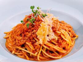 spaghetti bolognese med parmesan ost och tomater foto