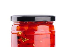 ljuv röd paprikor i en glas burk isolerat på en vit bakgrund foto