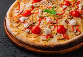 pizza med kyckling och tomater foto
