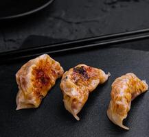 gyoza eller klimpar mellanmål på svart styrelse foto